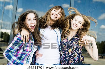 Stock Image - Three young women shaking hair in a row. Fotosearch
