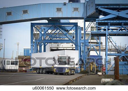 Truck loading containers onto ship in port View Large Photo Image Stock Image - Truck loading containers onto ship in port. Fotosearch