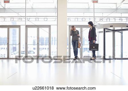 Two businesswomen arriving at conference centre View Large Photo Image Stock Photo - Two businesswomen arriving at conference centre. Fotosearch