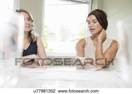 Two businesswomen discussing blueprint View Large Photo Image Stock Image - Two businesswomen discussing blueprint. Fotosearch