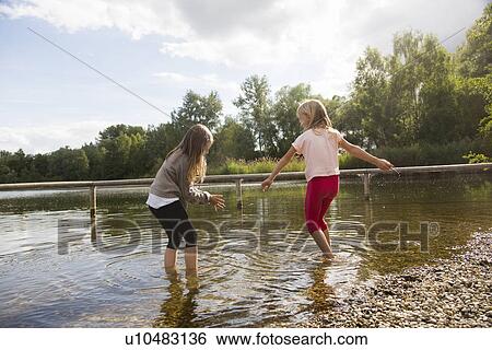Two girls paddling in lake View Large Photo Image Stock Photograph - Two girls paddling in lake. Fotosearch