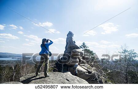 Two hikers on top of rock formation taking photographs View Large Photo Image Stock Photo - Two hikers on top of rock formation taking photographs. Fotosearch