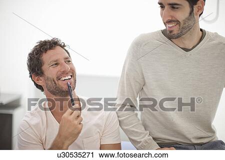 Stock Image - Two male colleagues laughing. Fotosearch