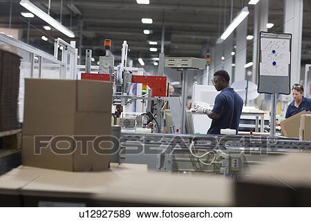 Two male workers in paper packaging factory View Large Photo Image Stock Photo - Two male workers in paper packaging factory. Fotosearch
