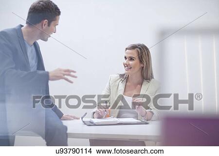 Two office workers in discussion View Large Photo Image Picture - Two office workers in discussion. Fotosearch