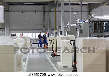 Stock Photography - Two workers in paper packaging factory. Fotosearch