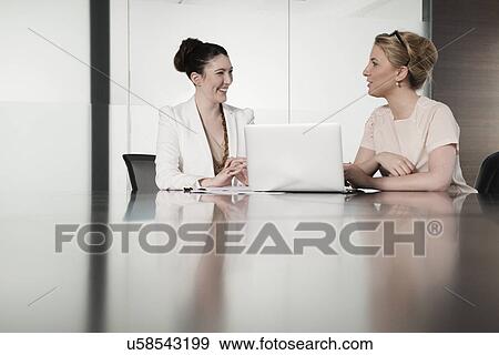 Two young businesswomen having face to face meeting in conference room View Large Photo Image Stock Photo - Two young businesswomen having face to face meeting in conference room. Fotosearch