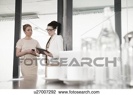 Two young businesswomen having meeting in conference room View Large Photo Image Stock Image - Two young businesswomen having meeting in conference room. Fotosearch