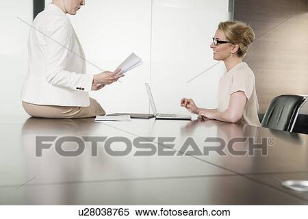 Two young businesswomen meeting face to face in boardroom View Large Photo Image Stock Photography - Two young businesswomen meeting face to face in boardroom. Fotosearch