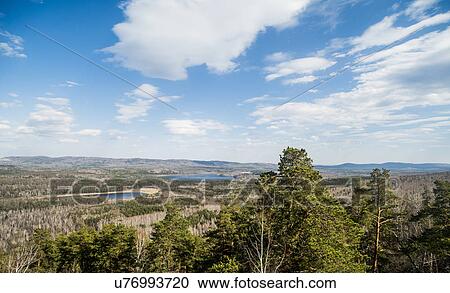 Stock Image - View of forest, mountains and lake. Fotosearch