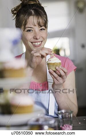 Woman decorating cupcake View Large Photo Image Stock Image - Woman decorating cupcake. Fotosearch