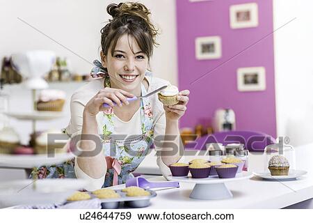 Woman decorating cupcake View Large Photo Image Stock Photo - Woman decorating cupcake. Fotosearch