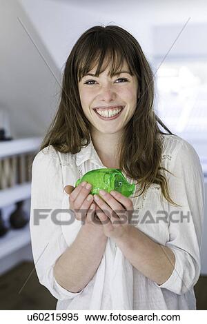 Woman holding green piggy bank View Large Photo Image Stock Photography - Woman holding green piggy bank. Fotosearch