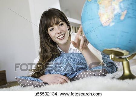 Woman pointing at globe View Large Photo Image Picture - Woman pointing at globe. Fotosearch