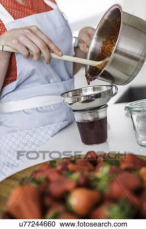 Woman pouring strawberry jam into jar View Large Photo Image Stock Image - Woman pouring strawberry jam into jar. Fotosearch