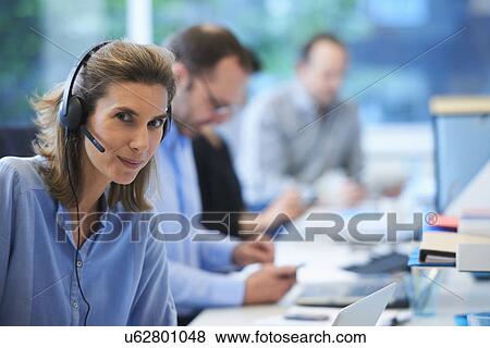 Woman wearing telephone headset in office View Large Photo Image Stock Photo - Woman wearing telephone headset in office. Fotosearch