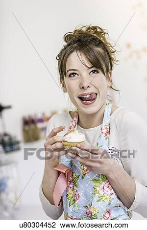 Woman with cupcake licking lips View Large Photo Image Stock Image - Woman with cupcake licking lips. Fotosearch