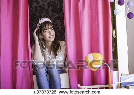 Woman with fluffy hairband sitting between pink curtains View Large Photo Image Stock Photograph - Woman with fluffy hairband sitting between pink curtains. Fotosearch
