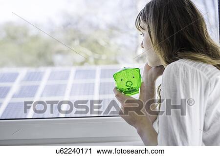 Woman with green piggy bank looking through window View Large Photo Image Stock Image - Woman with green piggy bank looking through window. Fotosearch