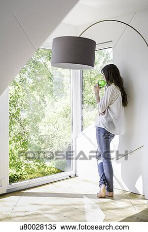 Woman with green piggy bank looking through window View Large Photo Image Stock Photography - Woman with green piggy bank looking through window. Fotosearch