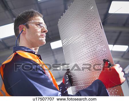 Worker inspecting newly cut parts in sheet metal factory View Large Photo Image Stock Photo - Worker inspecting newly cut parts in sheet metal factory. Fotosearch