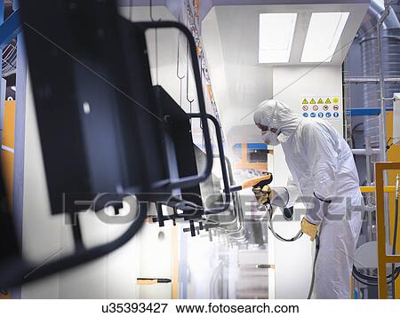 Worker powder coating parts in paint spray booth in sheet metal factory View Large Photo Image Stock Photo - Worker powder coating parts in paint spray booth in sheet metal factory. Fotosearch