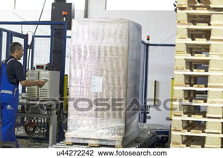 Worker using machine in paper packaging factory View Large Photo Image Stock Image - Worker using machine in paper packaging factory. Fotosearch