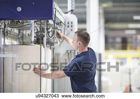 Worker using machine in paper packaging factory View Large Photo Image Stock Image - Worker using machine in paper packaging factory. Fotosearch