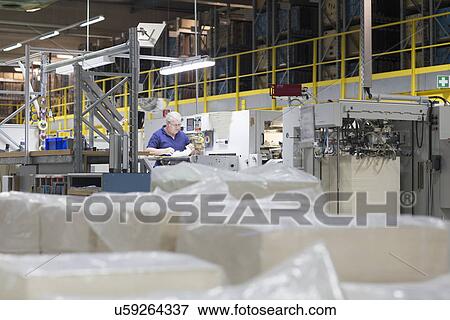 Worker using machine in paper packaging factory View Large Photo Image Stock Photo - Worker using machine in paper packaging factory. Fotosearch