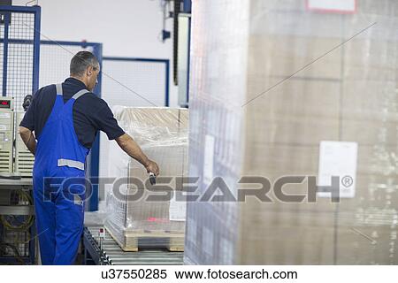 Worker using machine in paper packaging factory View Large Photo Image Stock Photography - Worker using machine in paper packaging factory. Fotosearch