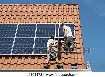 Workers installing solar panels on roof framework of new home, Netherlands View Large Photo Image Stock Image - Workers installing solar panels on roof framework of new home, Netherlands. Fotosearch