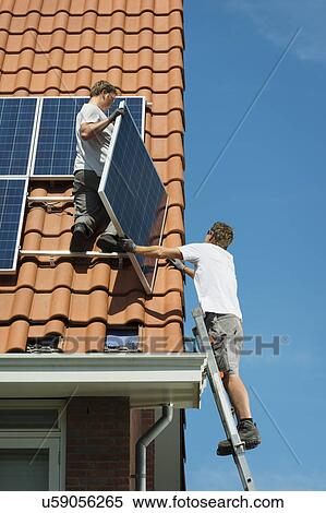 Workers installing solar panels on roof of new home, Netherlands View Large Photo Image Stock Photography - Workers installing solar panels on roof of new home, Netherlands. Fotosearch