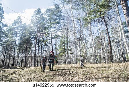 Young adult man and boy hiking in forest View Large Photo Image Stock Photography - Young adult man and boy hiking in forest. Fotosearch