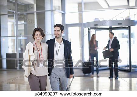 Young businessman and businesswoman arriving at conference centre View Large Photo Image Stock Photo - Young businessman and businesswoman arriving at conference centre. Fotosearch