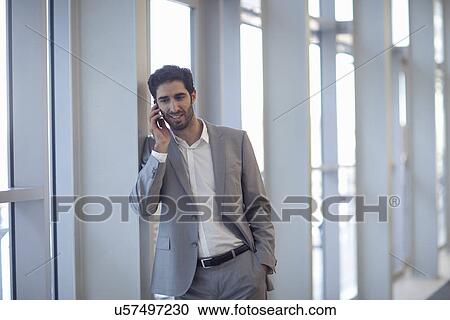 Young businessman chatting on smartphone in conference centre View Large Photo Image Stock Image - Young businessman chatting on smartphone in conference centre. Fotosearch