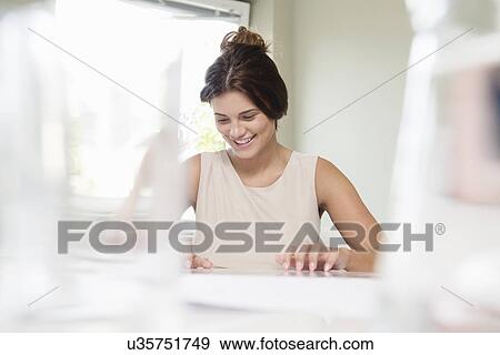Young businesswoman looking at paperwork in boardroom View Large Photo Image Stock Photo - Young businesswoman looking at paperwork in boardroom. Fotosearch
