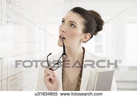 Young businesswoman looking at whiteboard View Large Photo Image Stock Photography - Young businesswoman looking at whiteboard. Fotosearch