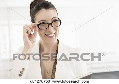 Young businesswoman looking over spectacles View Large Photo Image Stock Image - Young businesswoman looking over spectacles. Fotosearch