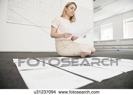 Young businesswoman organizing paperwork on office floor View Large Photo Image Picture - Young businesswoman organizing paperwork on office floor. Fotosearch