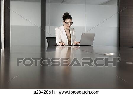 Young businesswoman using laptop in conference room View Large Photo Image Stock Image - Young businesswoman using laptop in conference room. Fotosearch