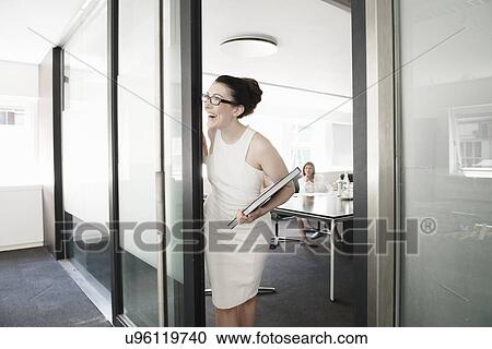 Young businesswoman waiting at conference room doorway View Large Photo Image Stock Image - Young businesswoman waiting at conference room doorway. Fotosearch