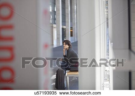 Stock Photography - Young businesswoman waiting conference centre corridor. Fotosearch