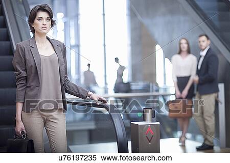 Young businesswoman with briefcase on escalator in conference centre View Large Photo Image Stock Photography - Young businesswoman with briefcase on escalator in conference centre. Fotosearch