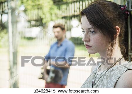 Young couple keeping distance in park after argument View Large Photo Image Stock Photography - Young couple keeping distance in park after argument. Fotosearch