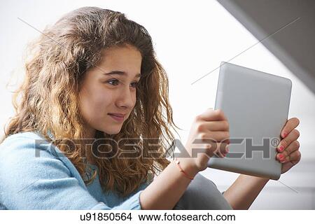 Young girl using digital tablet View Large Photo Image Picture - Young girl using digital tablet. Fotosearch