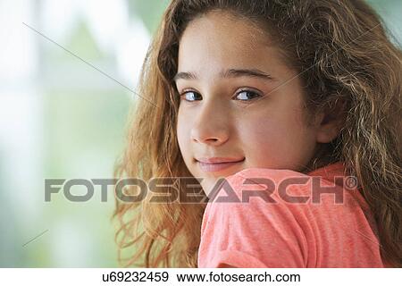 Stock Photo - Young girl with brown hair, smiling, portrait. Fotosearch