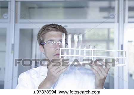 Young male scientist analyzing test tubes in lab View Large Photo Image Picture - Young male scientist analyzing test tubes in lab. Fotosearch