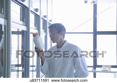Young male scientist looking at plastic bottle in lab View Large Photo Image Stock Image - Young male scientist looking at plastic bottle in lab. Fotosearch