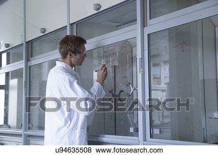 Young male scientist writing results on fume cupboard window View Large Photo Image Stock Photo - Young male scientist writing results on fume cupboard window. Fotosearch