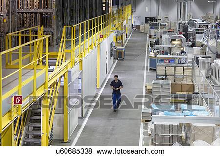 Young man working in paper packaging factory View Large Photo Image Stock Photo - Young man working in paper packaging factory. Fotosearch